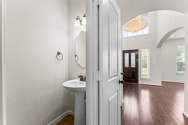 bathroom with a notable chandelier and hardwood / wood-style flooring