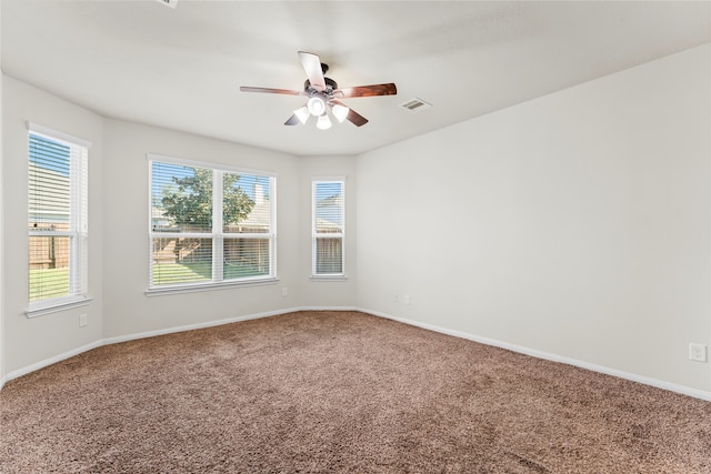 spare room featuring ceiling fan, carpet, and a wealth of natural light