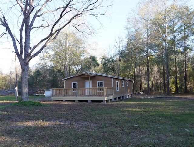 view of side of property with a deck and a lawn