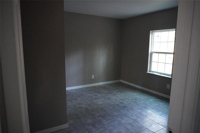 spare room featuring dark tile patterned flooring