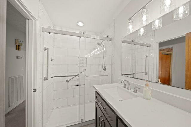 bathroom with a shower with door and vanity