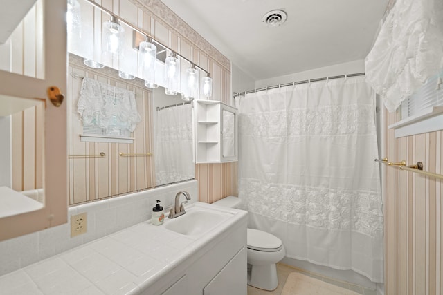 full bathroom with vanity, shower / tub combo with curtain, and toilet