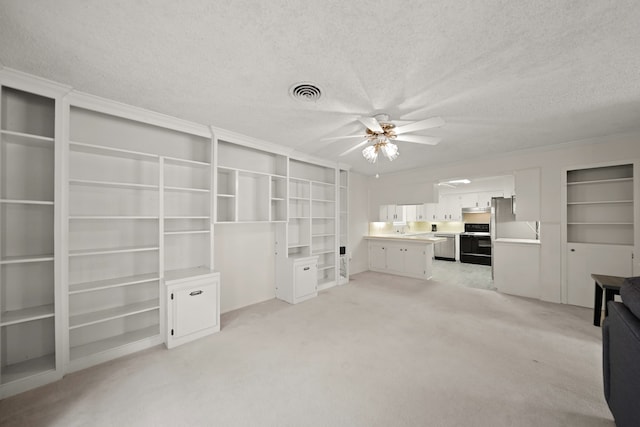 unfurnished living room featuring light carpet, a textured ceiling, sink, and ceiling fan