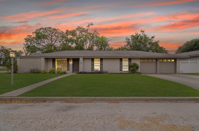 ranch-style house featuring a yard and a garage