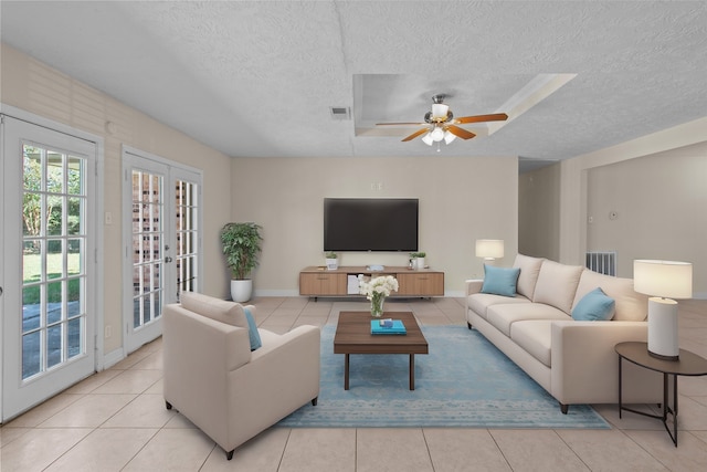 tiled living room featuring french doors, a textured ceiling, and ceiling fan