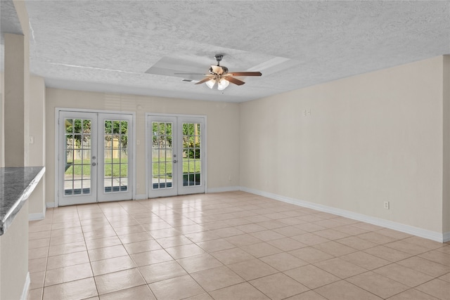 empty room featuring french doors, light tile patterned flooring, a textured ceiling, and ceiling fan