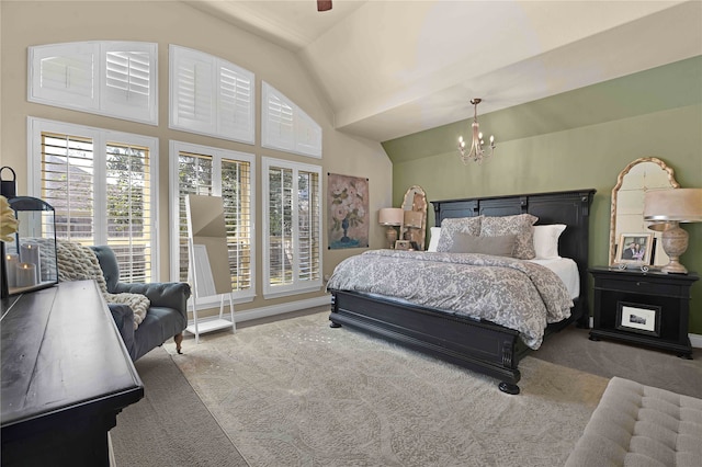 bedroom featuring carpet, lofted ceiling, and an inviting chandelier