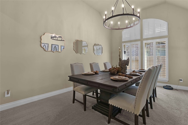 carpeted dining area with high vaulted ceiling and a chandelier