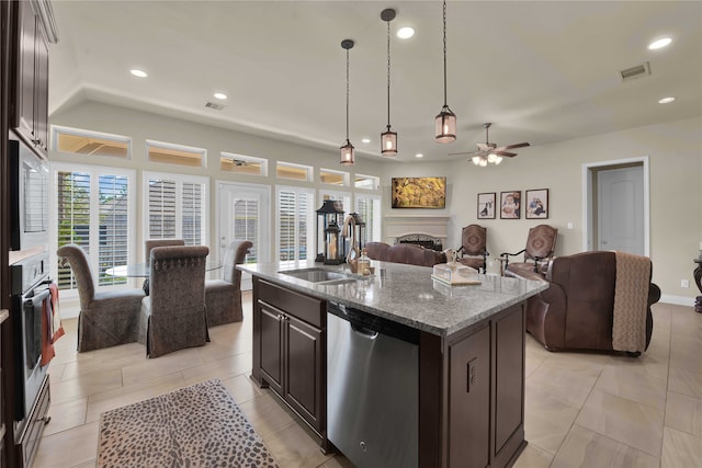 kitchen featuring appliances with stainless steel finishes, sink, ceiling fan, pendant lighting, and a kitchen island with sink