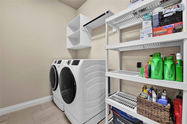 clothes washing area with independent washer and dryer and light tile patterned floors