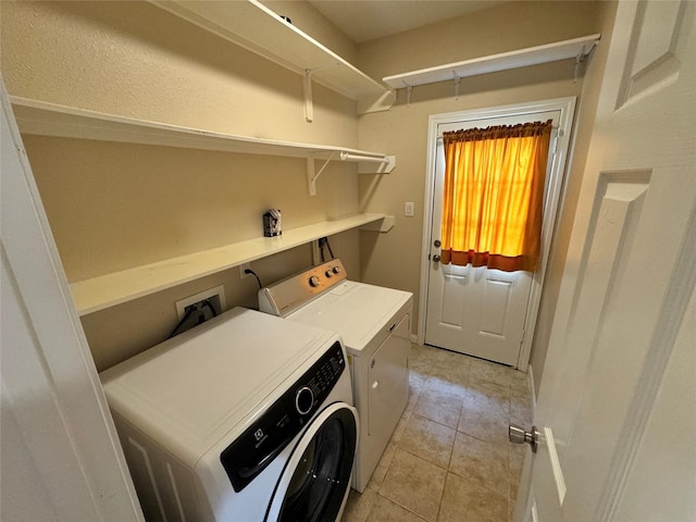 washroom with washer and dryer and light tile patterned floors