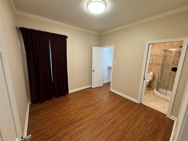 unfurnished bedroom featuring crown molding, hardwood / wood-style flooring, and ensuite bath