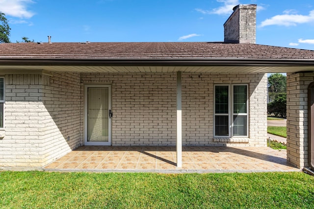 back of property featuring a patio and a lawn