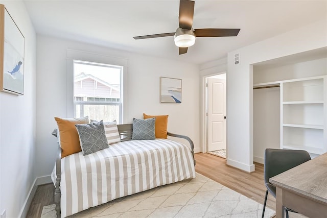 bedroom with a closet, ceiling fan, and light hardwood / wood-style flooring