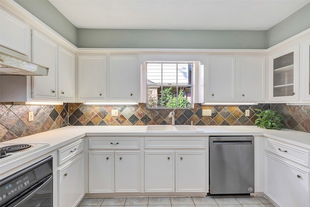 kitchen featuring stainless steel dishwasher, sink, white cabinetry, and black oven