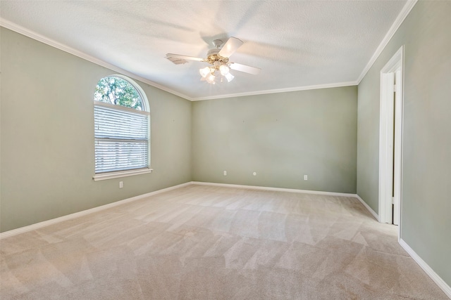 carpeted spare room featuring ceiling fan, ornamental molding, and a textured ceiling