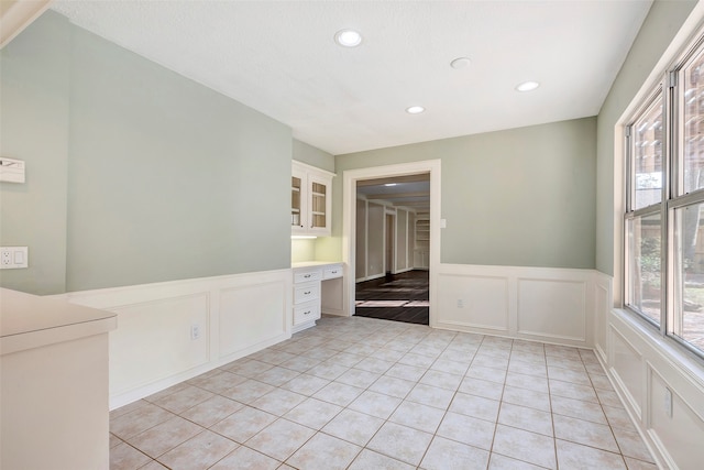 tiled spare room with built in desk and plenty of natural light