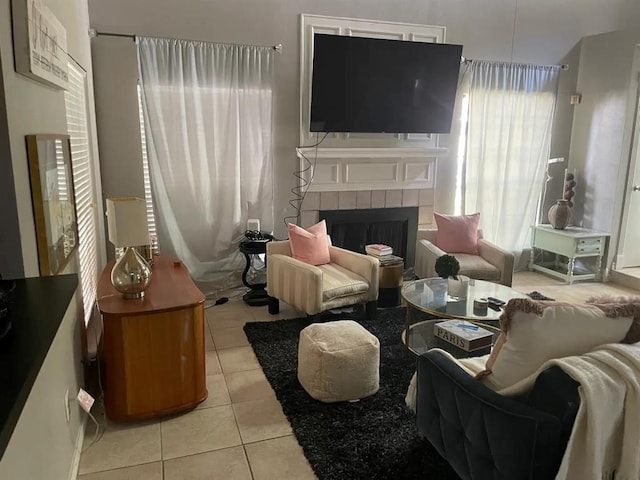 living area featuring light tile patterned floors, a wealth of natural light, and a tile fireplace