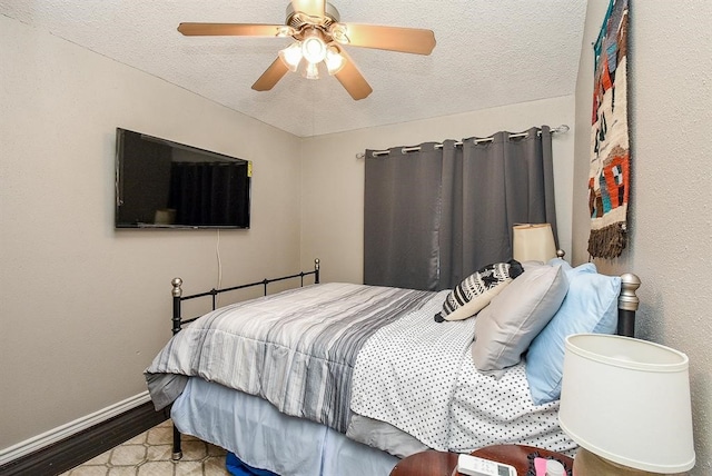 bedroom with a textured ceiling, hardwood / wood-style floors, and ceiling fan