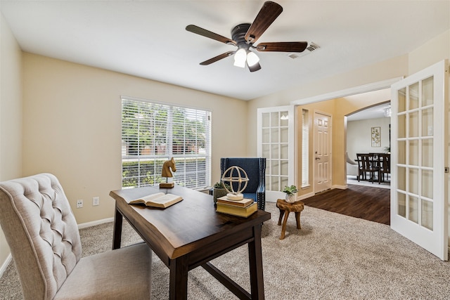 carpeted office space featuring french doors and ceiling fan