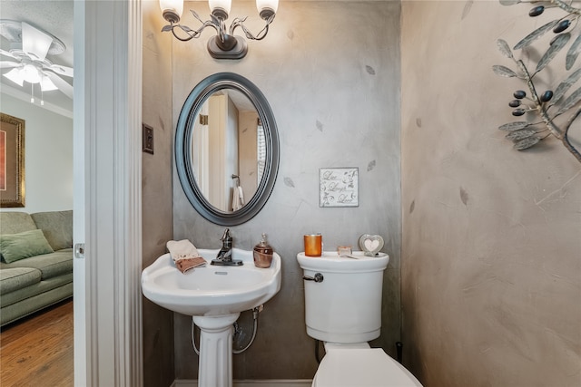 bathroom featuring ceiling fan, toilet, ornamental molding, and hardwood / wood-style flooring