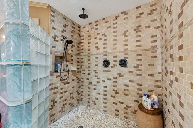 bathroom with tiled shower and a textured ceiling