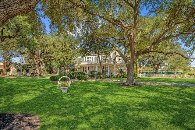 view of front of house with fence and a front lawn