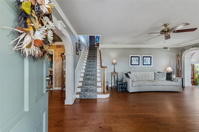 unfurnished living room featuring dark hardwood / wood-style flooring, ceiling fan, and crown molding