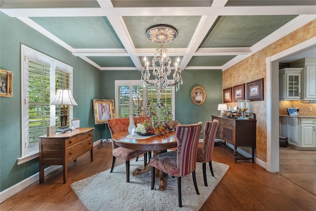 dining room featuring beam ceiling, coffered ceiling, a chandelier, hardwood / wood-style flooring, and ornamental molding