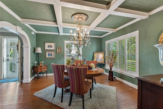 dining room with ornamental molding, coffered ceiling, beam ceiling, a chandelier, and hardwood / wood-style floors