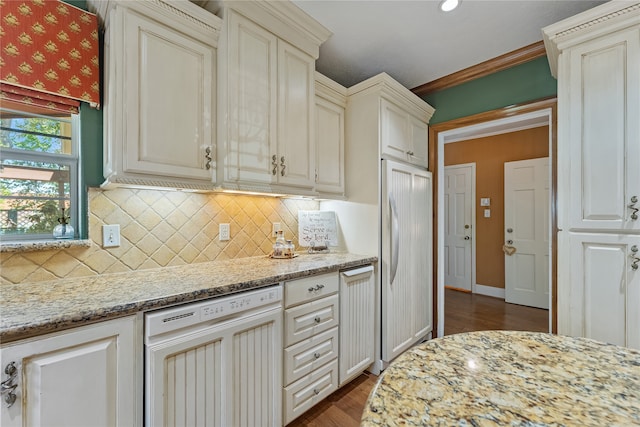 kitchen with dark hardwood / wood-style flooring, light stone counters, white dishwasher, crown molding, and fridge