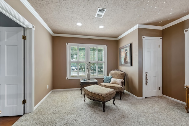 sitting room with carpet, crown molding, and a textured ceiling