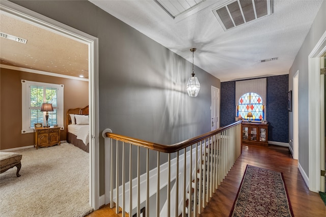 hall featuring crown molding, dark hardwood / wood-style flooring, and a textured ceiling