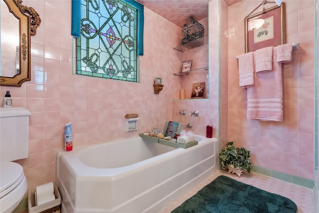 bathroom featuring a bathtub, tile walls, and toilet