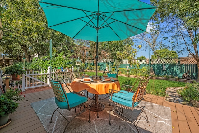 wooden deck featuring outdoor dining area and a fenced backyard