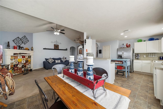 dining space featuring ceiling fan, light carpet, and lofted ceiling