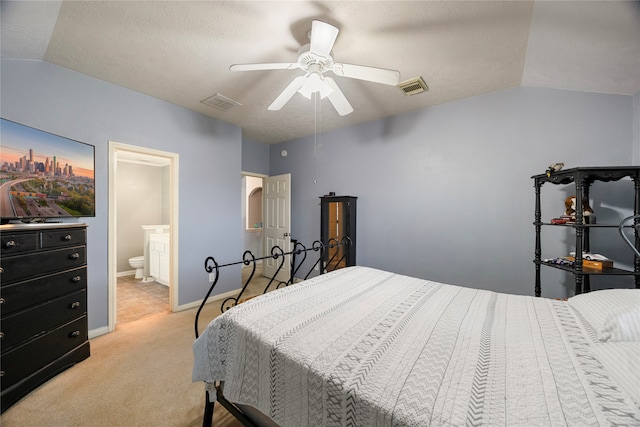 carpeted bedroom featuring ceiling fan, connected bathroom, a textured ceiling, and vaulted ceiling