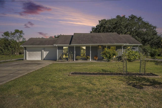 ranch-style home with a yard, covered porch, and a garage