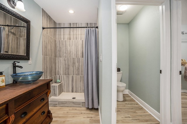 bathroom with curtained shower, hardwood / wood-style floors, vanity, and toilet