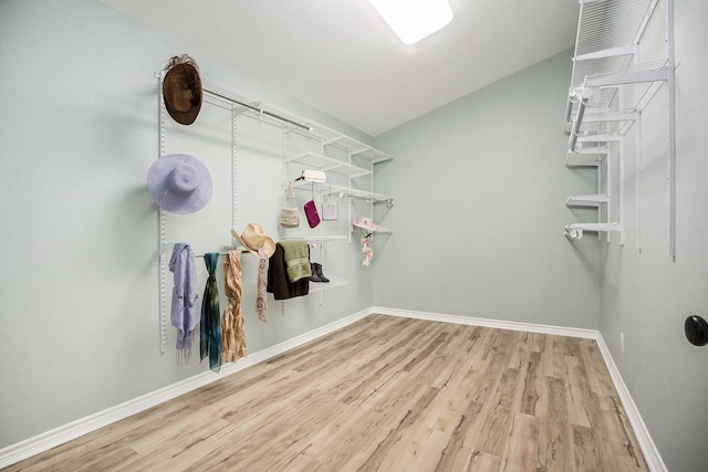 spacious closet featuring hardwood / wood-style floors and vaulted ceiling