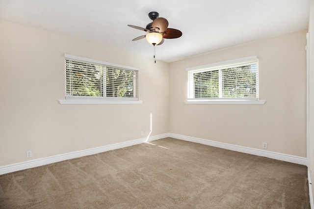 spare room featuring ceiling fan, a healthy amount of sunlight, and light colored carpet