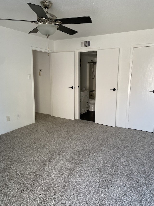 unfurnished bedroom featuring ensuite bathroom, carpet floors, and ceiling fan