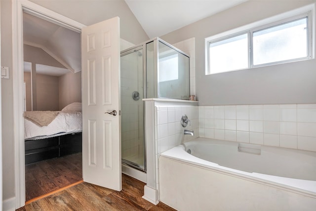 bathroom with lofted ceiling, shower with separate bathtub, and hardwood / wood-style floors