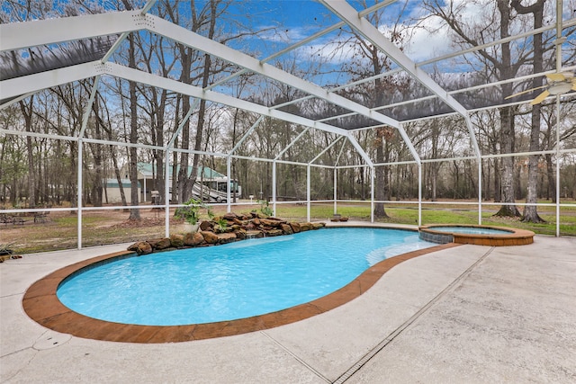 view of pool featuring an in ground hot tub, a patio, a lawn, and a lanai