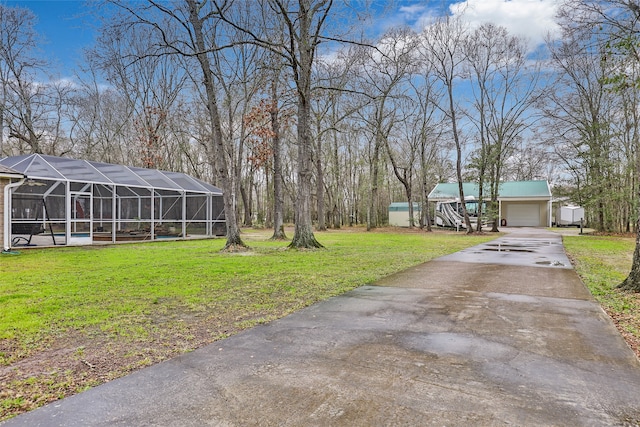 view of yard featuring glass enclosure and a garage