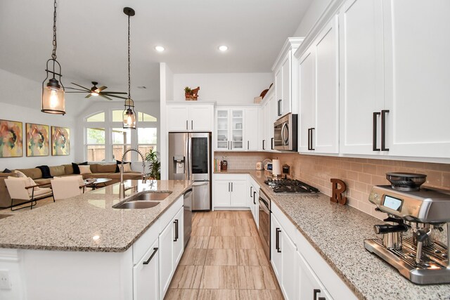 kitchen with sink, appliances with stainless steel finishes, decorative light fixtures, and white cabinetry