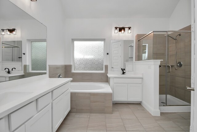 bathroom with vanity and shower with separate bathtub