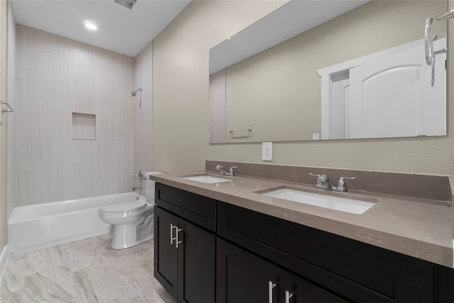 full bathroom with tiled shower / bath, vanity, and toilet