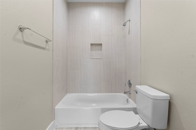 bathroom featuring toilet and tiled shower / bath combo