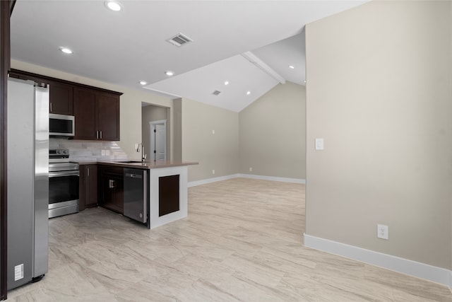 kitchen with appliances with stainless steel finishes, sink, dark brown cabinets, kitchen peninsula, and vaulted ceiling